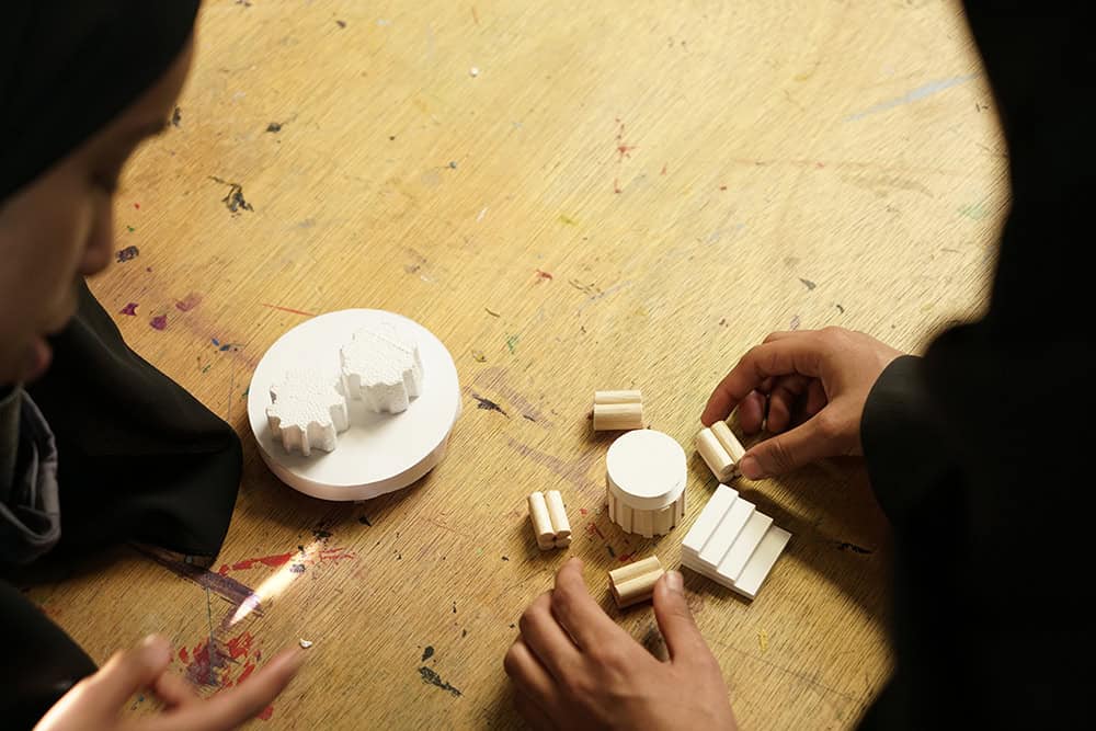 Students assemble models at a workshop table