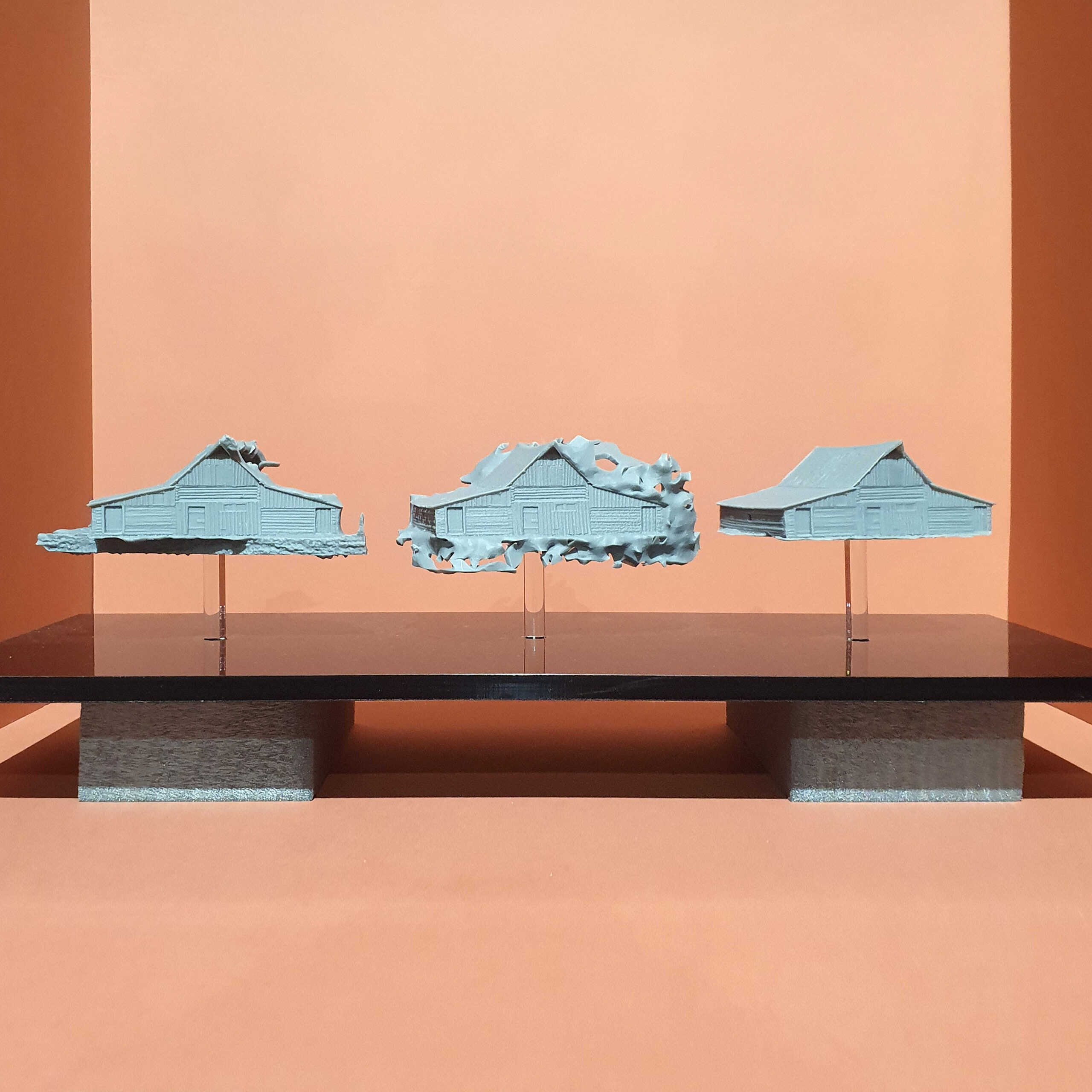 Three pale-blue 3D-printed barn models displayed together